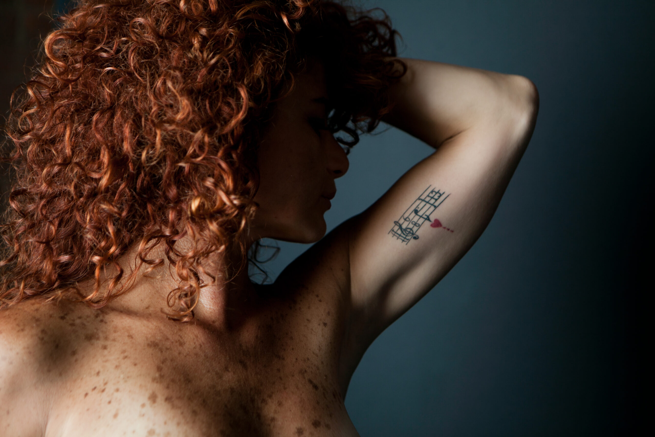 Image of a woman with red hair and tattoo